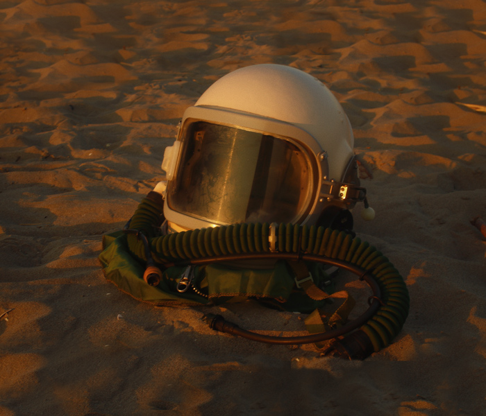 An astronaut's helmet laying in the sand