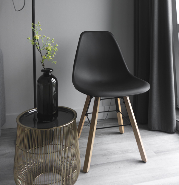 A beautiful black Chair up in a light livingroom