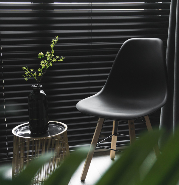 A black Chair up surrounded by green plants